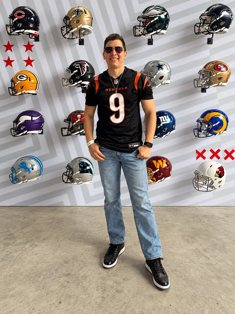 Carlos frente al muro de cascos de la NFL